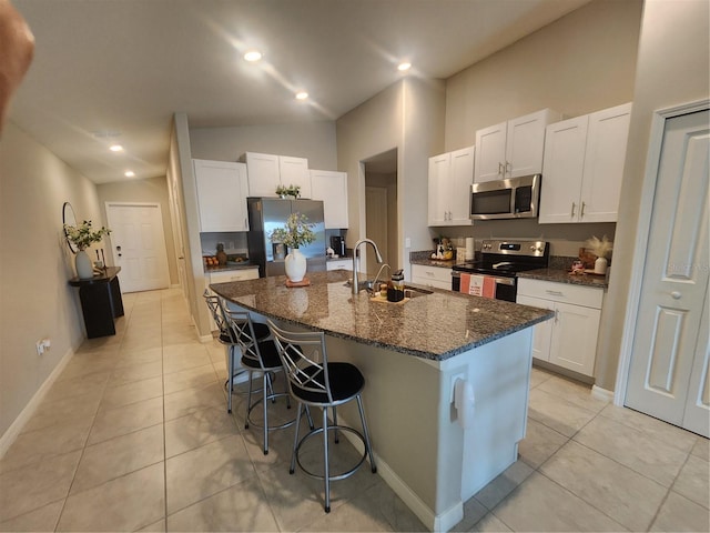 16725 Delia St, Wimauma, FL 33598 - kitchen with appliances with stainless steel finishes, light tile patterned floors, a center island with sink, a kitchen breakfast bar, and recessed lighting