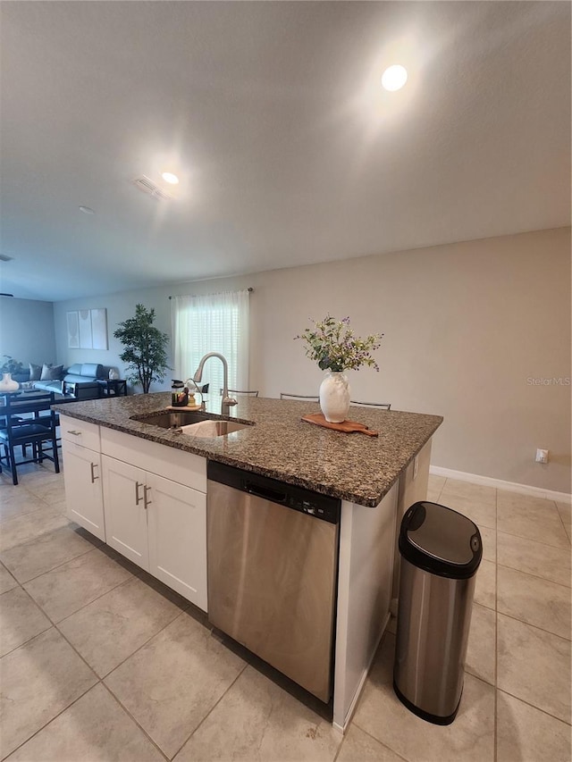 16725 Delia St, Wimauma, FL 33598 - kitchen with stainless steel dishwasher, an island with sink, open floor plan, light tile patterned floors, and dark stone counters