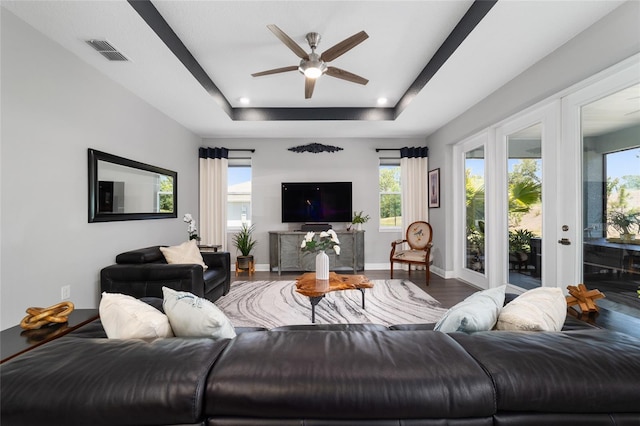 10298 SW 96th Loop, Ocala, FL 34481 - living room featuring ceiling fan, wood finished floors, a raised ceiling, and baseboards