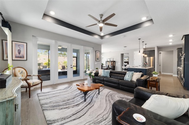 10298 SW 96th Loop, Ocala, FL 34481 - living area featuring a ceiling fan, a raised ceiling, recessed lighting, light wood-style flooring, and french doors