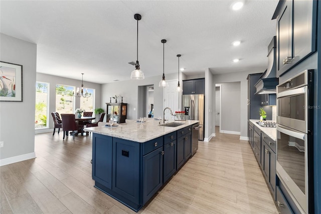 10298 SW 96th Loop, Ocala, FL 34481 - kitchen featuring a sink, appliances with stainless steel finishes, a chandelier, baseboards, and wall chimney exhaust hood
