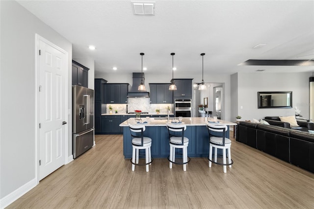 10298 SW 96th Loop, Ocala, FL 34481 - kitchen with appliances with stainless steel finishes, custom exhaust hood, open floor plan, and light wood-type flooring
