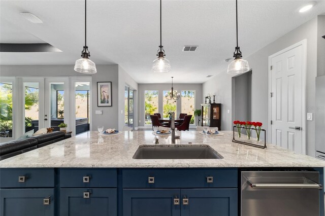10298 SW 96th Loop, Ocala, FL 34481 - kitchen with open floor plan, blue cabinetry, a sink, a center island with sink, and hanging light fixtures