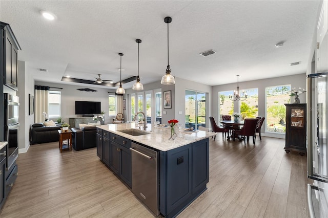 10298 SW 96th Loop, Ocala, FL 34481 - kitchen with stainless steel appliances, a sink, light wood finished floors, ceiling fan, and a textured ceiling
