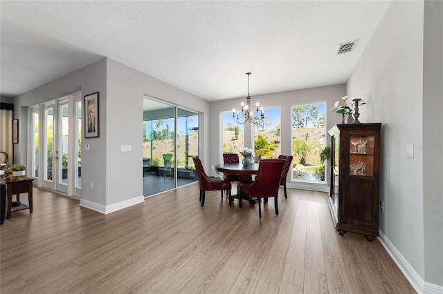 10298 SW 96th Loop, Ocala, FL 34481 - dining space with a chandelier, light wood-style floors, and baseboards