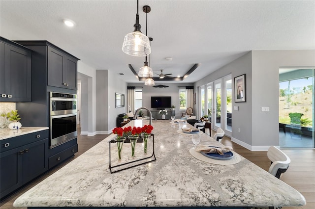 10298 SW 96th Loop, Ocala, FL 34481 - kitchen with open floor plan, stainless steel double oven, dark wood finished floors, a large island, and a textured ceiling
