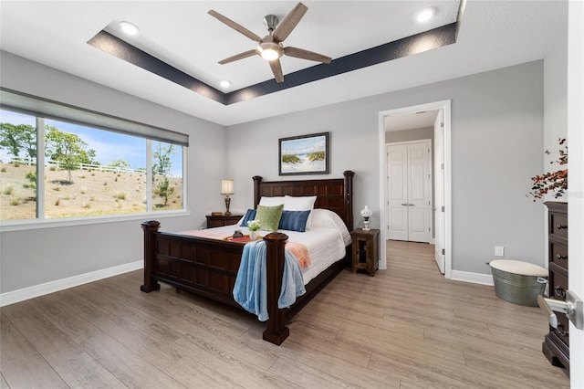 10298 SW 96th Loop, Ocala, FL 34481 - bedroom with a tray ceiling, light wood-type flooring, baseboards, recessed lighting, and ceiling fan