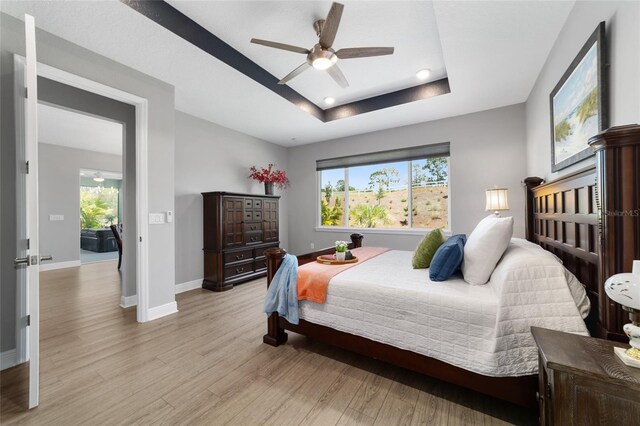 10298 SW 96th Loop, Ocala, FL 34481 - bedroom featuring light wood-style flooring, a tray ceiling, baseboards, and recessed lighting