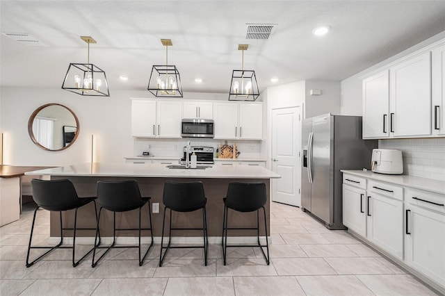 30572 Thunderbird Dr, Wesley Chapel, FL 33545 - kitchen with appliances with stainless steel finishes, decorative backsplash, light countertops, a breakfast bar area, and recessed lighting