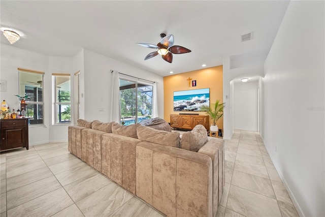 603 Loma Del Sol Dr, Davenport, FL 33896 - living room featuring a ceiling fan, arched walkways, and light tile patterned floors