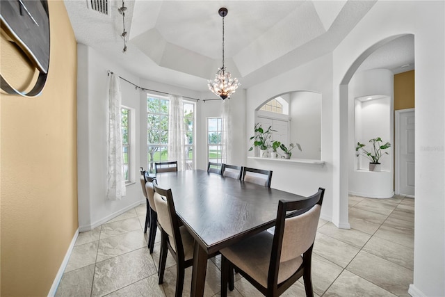 603 Loma Del Sol Dr, Davenport, FL 33896 - dining area featuring a chandelier, a tray ceiling, and light marble finish flooring