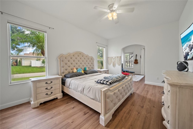 603 Loma Del Sol Dr, Davenport, FL 33896 - bedroom with light wood-type flooring, arched walkways, and ceiling fan