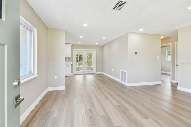1110 Canal St, Ruskin, FL 33570 - unfurnished living room featuring healthy amount of natural light, light wood-style floors, baseboards, french doors, and recessed lighting