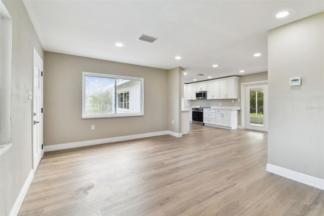 1110 Canal St, Ruskin, FL 33570 - unfurnished living room featuring light wood-style flooring, baseboards, and recessed lighting