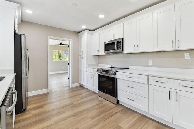 1110 Canal St, Ruskin, FL 33570 - kitchen with appliances with stainless steel finishes, white cabinetry, light wood finished floors, recessed lighting, and a ceiling fan