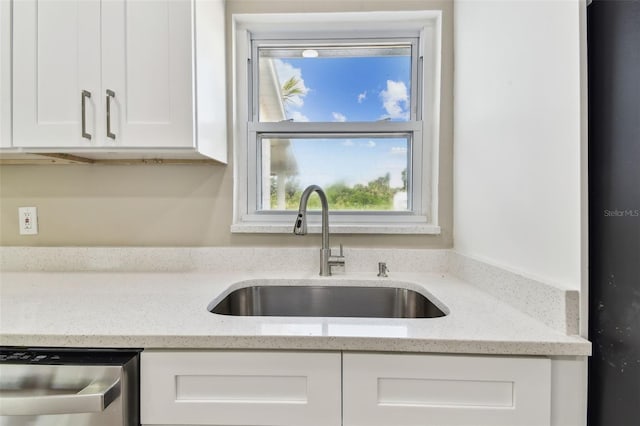 1110 Canal St, Ruskin, FL 33570 - kitchen featuring a sink, white cabinetry, stainless steel dishwasher, and light stone countertops