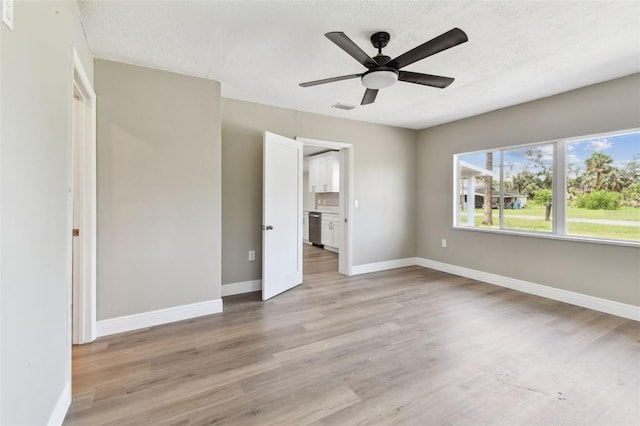 1110 Canal St, Ruskin, FL 33570 - unfurnished bedroom featuring light wood-type flooring, baseboards, a textured ceiling, and ceiling fan