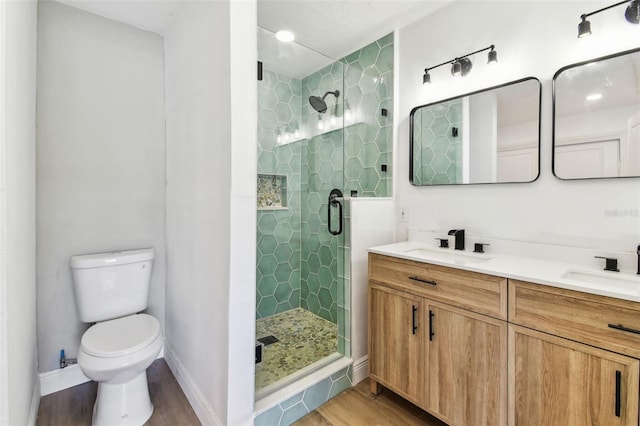 1110 Canal St, Ruskin, FL 33570 - bathroom featuring wood finished floors, a shower stall, double vanity, toilet, and baseboards