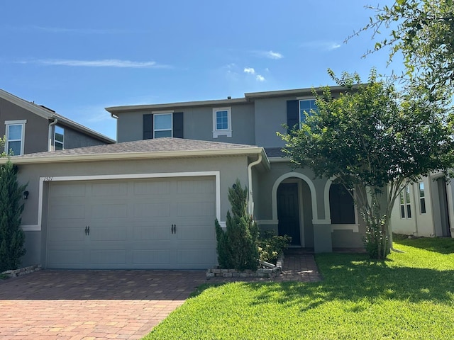 1521 Sourwood Dr, Ocoee, FL 34761 - traditional home featuring stucco siding, an attached garage, a front yard, and driveway