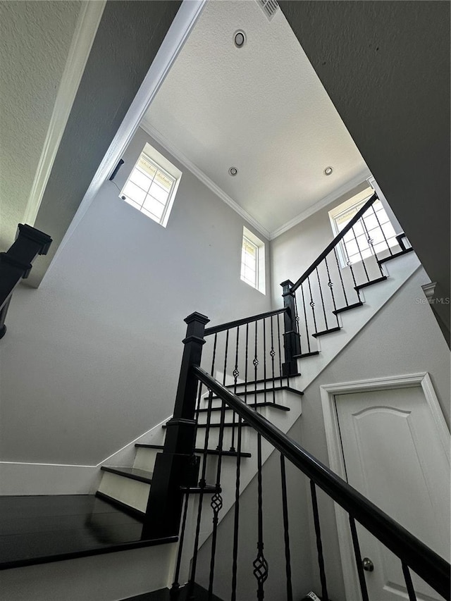 1521 Sourwood Dr, Ocoee, FL 34761 - staircase featuring crown molding, a towering ceiling, recessed lighting, and a textured ceiling