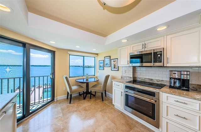 240 Sand Key Estates Dr Unit 222, Clearwater, FL 33767 - kitchen with appliances with stainless steel finishes, a raised ceiling, decorative backsplash, baseboards, and recessed lighting