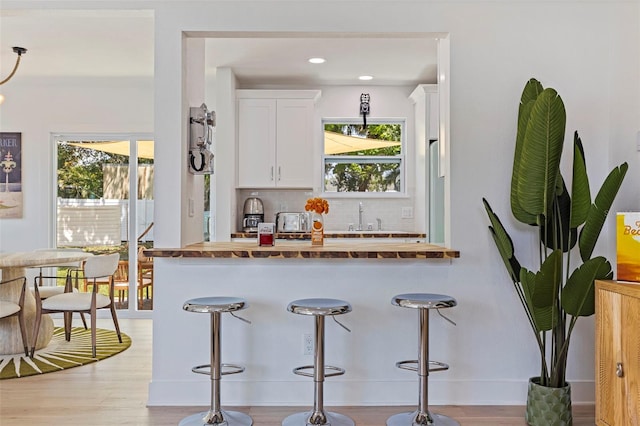 1579 Bayshore Blvd, Dunedin, FL 34698 - bar featuring decorative backsplash, light wood-style flooring, a sink, recessed lighting, and baseboards