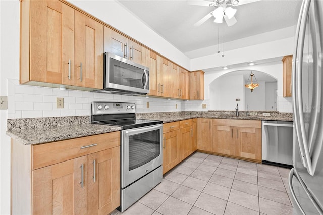 3512 Tealwood Cir, Palm Harbor, FL 34685 - kitchen with stainless steel appliances, arched walkways, decorative backsplash, a ceiling fan, and light tile patterned floors