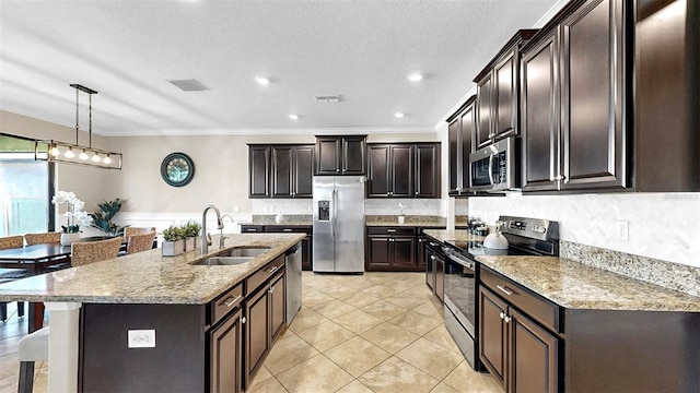 13903 Sage Thrasher Ln, Riverview, FL 33579 - kitchen featuring appliances with stainless steel finishes, ornamental molding, light stone counters, decorative light fixtures, and a kitchen island with sink