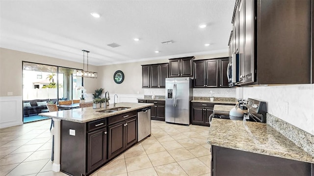 13903 Sage Thrasher Ln, Riverview, FL 33579 - kitchen with stainless steel appliances, crown molding, light tile patterned floors, an island with sink, and light stone counters