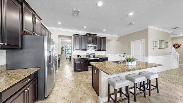 13903 Sage Thrasher Ln, Riverview, FL 33579 - kitchen featuring appliances with stainless steel finishes, ornamental molding, a center island with sink, a kitchen breakfast bar, and light tile patterned floors