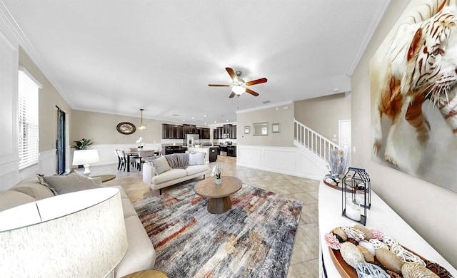 13903 Sage Thrasher Ln, Riverview, FL 33579 - living room featuring ornamental molding, ceiling fan, stairway, a decorative wall, and wainscoting