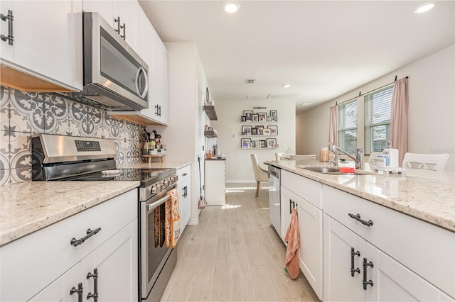 13958 Richland Gulf Cir, Parrish, FL 34219 - kitchen featuring appliances with stainless steel finishes, decorative backsplash, recessed lighting, white cabinets, and light stone countertops