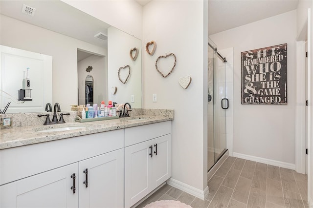 13958 Richland Gulf Cir, Parrish, FL 34219 - bathroom with double vanity, a stall shower, baseboards, and wood finish floors