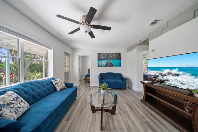 12304 Woodleigh Ave, Tampa, FL 33612 - living room with light wood-style floors, ceiling fan, and baseboards