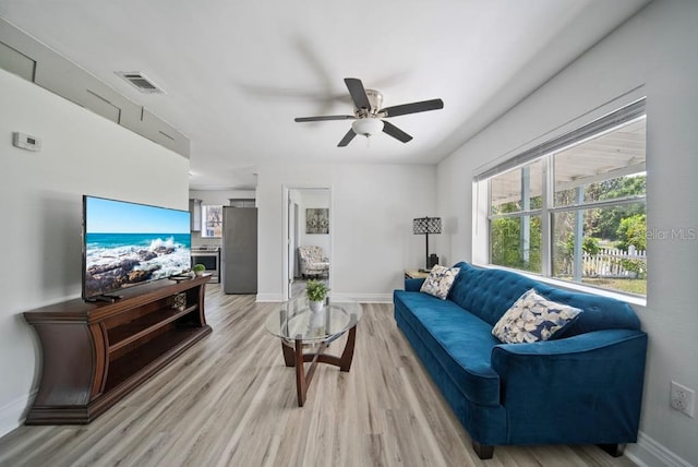 12304 Woodleigh Ave, Tampa, FL 33612 - living room featuring light wood finished floors, a ceiling fan, and baseboards