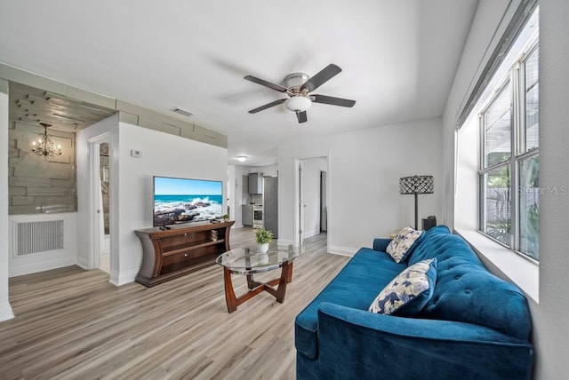 12304 Woodleigh Ave, Tampa, FL 33612 - living area with a chandelier, light wood finished floors, baseboards, and a ceiling fan