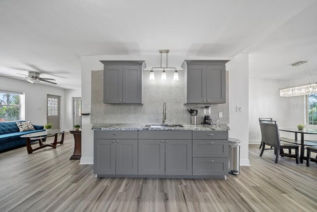 12304 Woodleigh Ave, Tampa, FL 33612 - kitchen featuring gray cabinetry, a sink, a ceiling fan, and light wood-type flooring