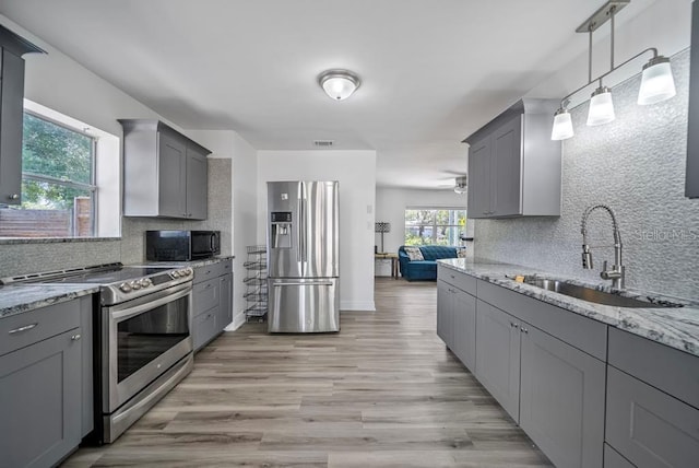 12304 Woodleigh Ave, Tampa, FL 33612 - kitchen featuring appliances with stainless steel finishes, a sink, gray cabinetry, and decorative backsplash