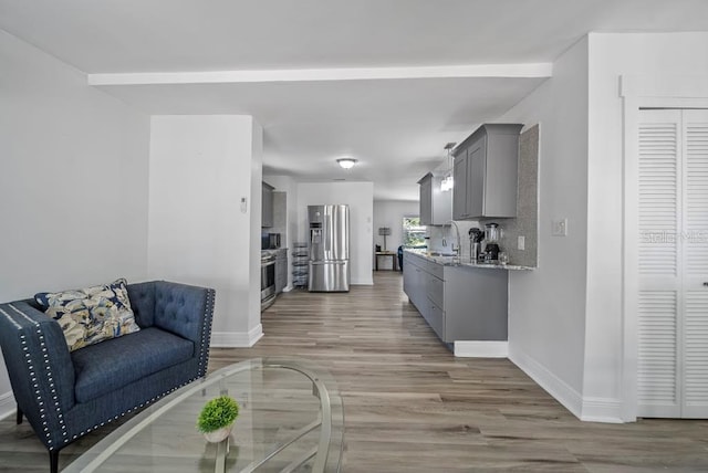12304 Woodleigh Ave, Tampa, FL 33612 - living room featuring light wood finished floors and baseboards