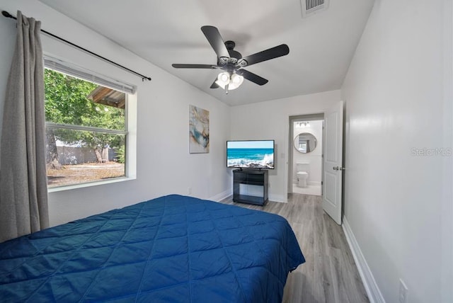 12304 Woodleigh Ave, Tampa, FL 33612 - bedroom featuring wood finished floors, baseboards, ensuite bath, and a ceiling fan