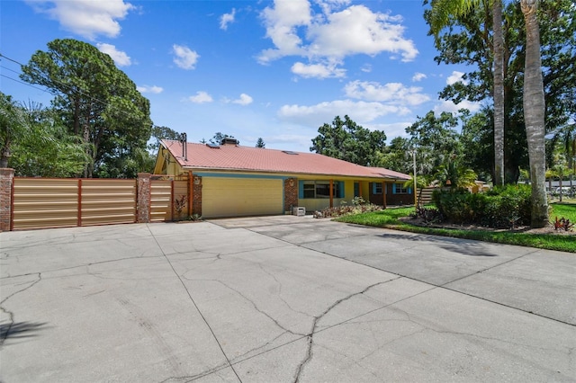 7507 Beasley Rd, Tampa, FL 33615 - view of front of home with a garage, a chimney, concrete driveway, and a gate