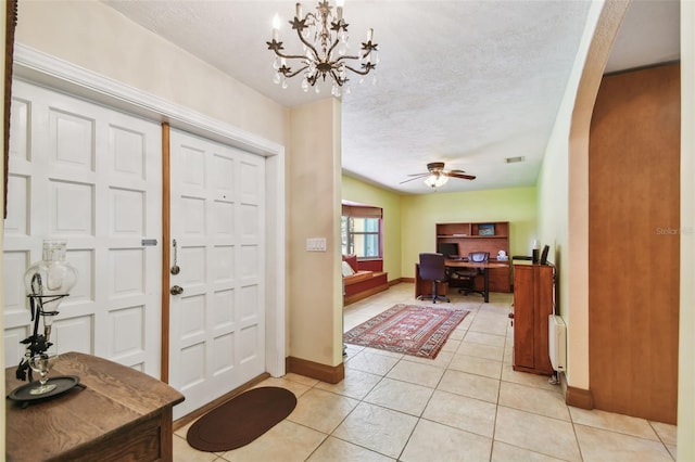 7507 Beasley Rd, Tampa, FL 33615 - foyer with radiator, baseboards, light tile patterned floors, a textured ceiling, and a chandelier