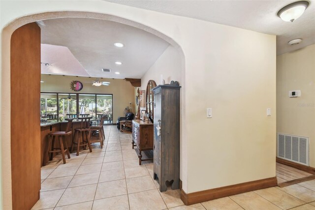 7507 Beasley Rd, Tampa, FL 33615 - hallway featuring light tile patterned floors, arched walkways, baseboards, and recessed lighting