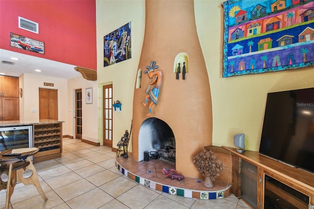 7507 Beasley Rd, Tampa, FL 33615 - living room featuring a towering ceiling, light tile patterned floors, wine cooler, a bar, and baseboards