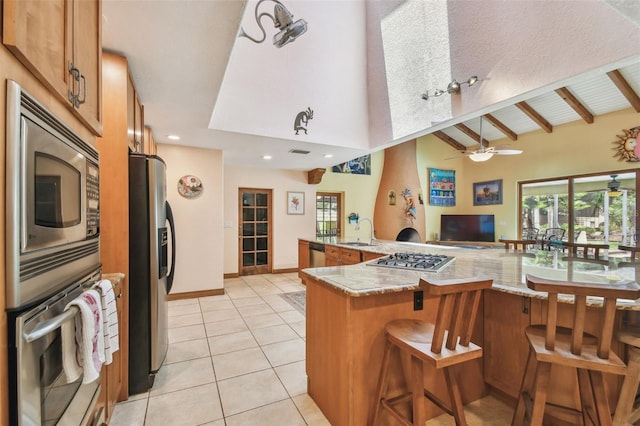 7507 Beasley Rd, Tampa, FL 33615 - kitchen with a sink, appliances with stainless steel finishes, brown cabinets, a ceiling fan, and light tile patterned flooring