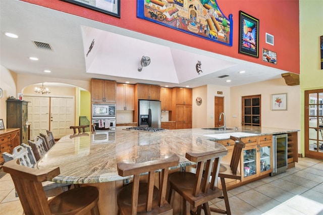 7507 Beasley Rd, Tampa, FL 33615 - dining space with wine cooler, arched walkways, light tile patterned floors, a chandelier, and recessed lighting