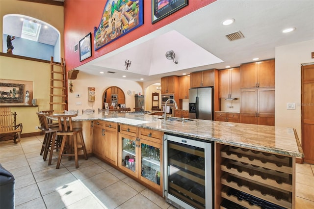 7507 Beasley Rd, Tampa, FL 33615 - kitchen with wine cooler, appliances with stainless steel finishes, light tile patterned flooring, a sink, and a peninsula