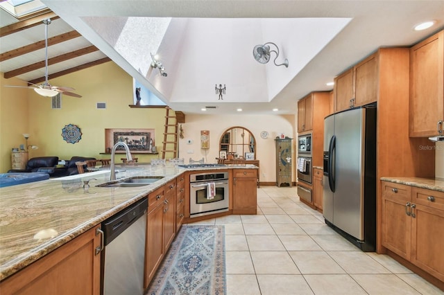 7507 Beasley Rd, Tampa, FL 33615 - kitchen with stainless steel appliances, a skylight, a sink, brown cabinets, and open floor plan