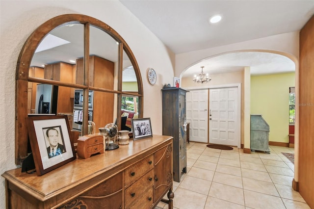7507 Beasley Rd, Tampa, FL 33615 - foyer entrance with arched walkways, light tile patterned floors, a chandelier, and recessed lighting