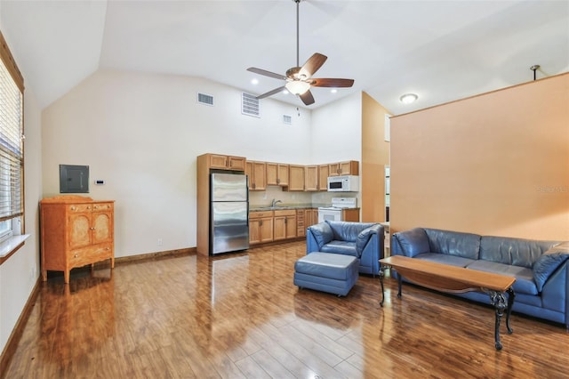 7507 Beasley Rd, Tampa, FL 33615 - living area with wood finished floors, ceiling fan, electric panel, baseboards, and high vaulted ceiling
